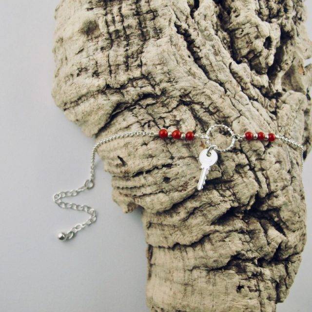 Ce bracelet est composé d'une fine chaîne en argent massif et perles 2,5mm de véritable corail rouge de Méditerranée. Un anneau en argent martelé porte le petit charms. A vous de choisir