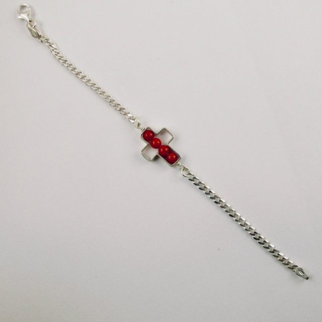 Une chaîne maille gourmette et 4 perles 4 mm de véritable corail rouge de Méditerranée, délicatement enchâssées dans une croix ajourée,  en argent 925/1000e