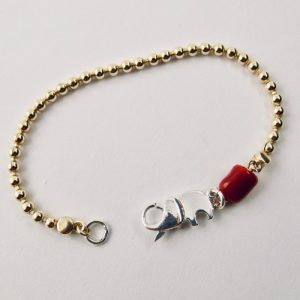 Le bracelet Kokkiri, avec son fermoir en forme d'éléphant en argent 925/1000e, est composé d'une chaîne boule en argent plaqué or et d'une grosse perle irrégulière de véritable corail rouge de Méditerranée