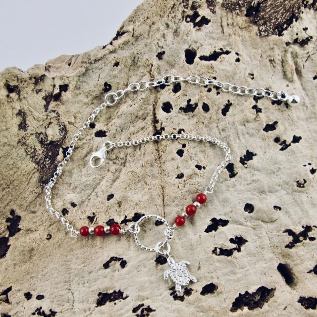 Ce bracelet est composé d'une fine chaîne en argent massif et perles 2,5mm de véritable corail rouge de Méditerranée. Un anneau en argent martelé porte le petit charms. A vous de choisir