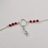 Ce bracelet est composé d'une fine chaîne en argent massif et perles 2,5mm de véritable corail rouge de Méditerranée. Un anneau en argent martelé porte le petit charms. A vous de choisir