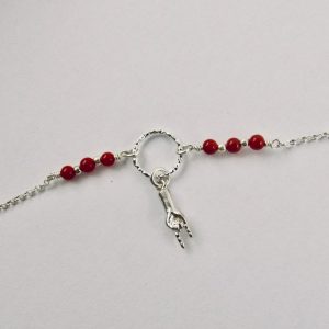 Ce bracelet est composé d'une fine chaîne en argent massif et perles 2,5mm de véritable corail rouge de Méditerranée. Un anneau en argent martelé porte le petit charms. A vous de choisir