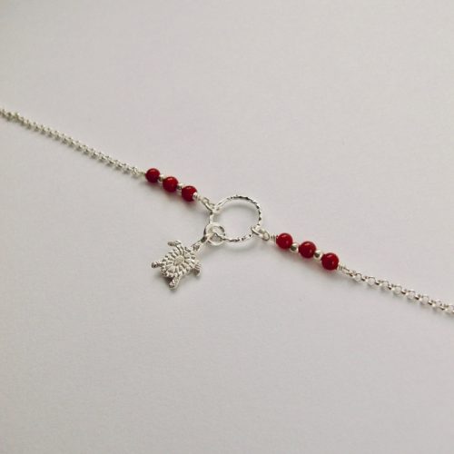 Ce bracelet est composé d'une fine chaîne en argent massif et perles 2,5mm de véritable corail rouge de Méditerranée. Un anneau en argent martelé porte le petit charms. A vous de choisir