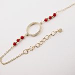 Ce bracelet est composé d'une fine chaîne en argent plaqué or et perles 2,5mm de véritable corail rouge de Méditerranée, reliée à un anneau (ø 13mm) serti de cristaux de swarovski.