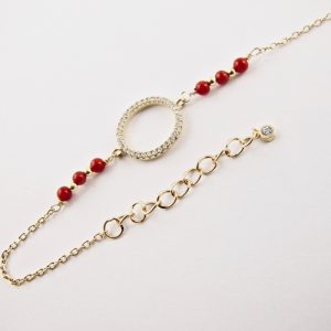 Ce bracelet est composé d'une fine chaîne en argent plaqué or et perles 2,5mm de véritable corail rouge de Méditerranée, reliée à un anneau (ø 13mm) serti de cristaux de swarovski.