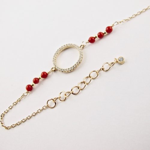 Ce bracelet est composé d'une fine chaîne en argent plaqué or et perles 2,5mm de véritable corail rouge de Méditerranée, reliée à un anneau (ø 13mm) serti de cristaux de swarovski.