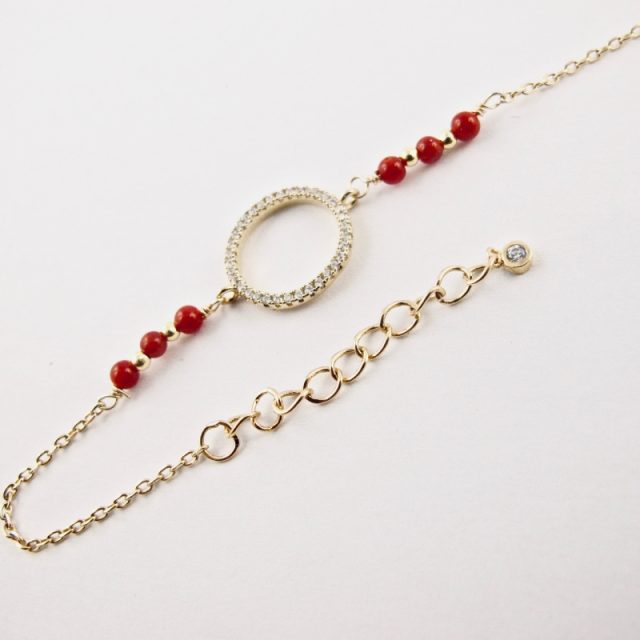 Ce bracelet est composé d'une fine chaîne en argent plaqué or et perles 2,5mm de véritable corail rouge de Méditerranée, reliée à un anneau (ø 13mm) serti de cristaux de swarovski.