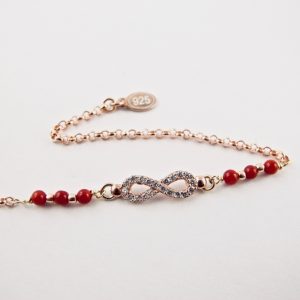 Ce bracelet est composé d'une fine chaîne en argent plaqué or rose et perles 2,5mm de véritable corail rouge de Méditerranée, reliée à un infini serti de cristaux de swarovski.