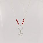 Ce collier est composé d'une fine chaîne en argent massif et perles 2,5mm de véritable corail rouge de Méditerranée. Un anneau en argent martelé porte le petit charms.