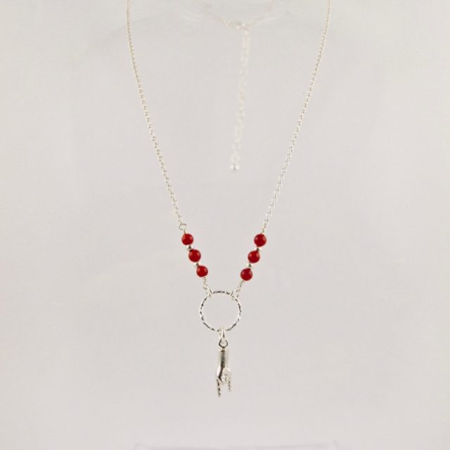 Ce collier est composé d'une fine chaîne en argent massif et perles 2,5mm de véritable corail rouge de Méditerranée. Un anneau en argent martelé porte le petit charms.