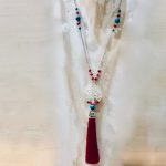 Collier sautoir en argent 925/1000,  composé de petites perles de véritable corail rouge de Méditerranée, de perles de turquoise et perles de cristal facetées . Disque de nacre sculpté arbre de vie et pompon rouge