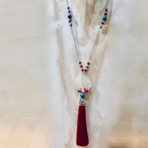 Collier sautoir en argent 925/1000,  composé de petites perles de véritable corail rouge de Méditerranée, de perles de turquoise et perles de cristal facetées . Disque de nacre sculpté arbre de vie et pompon rouge