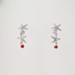 Boucles d'oreilles stelle, deux petites étoiles en argent massif et leur perle de véritable corail rouge de Méditerranée, monté sur clou argent