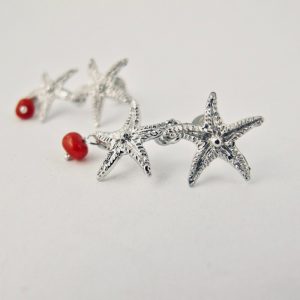 Boucles d'oreilles stelle, deux petites étoiles en argent massif et leur perle de véritable corail rouge de Méditerranée, monté sur clou argent