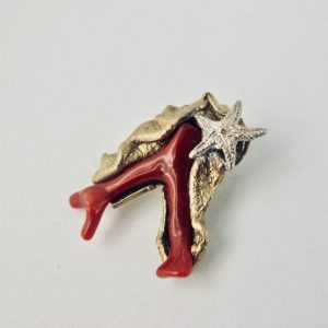 Pendentif ramo,  branche de véritable corail rouge de Méditerranée enveloppée d'une feuille de bronze plaqué or, ornée d'une petite étoile de mer en argent massif.