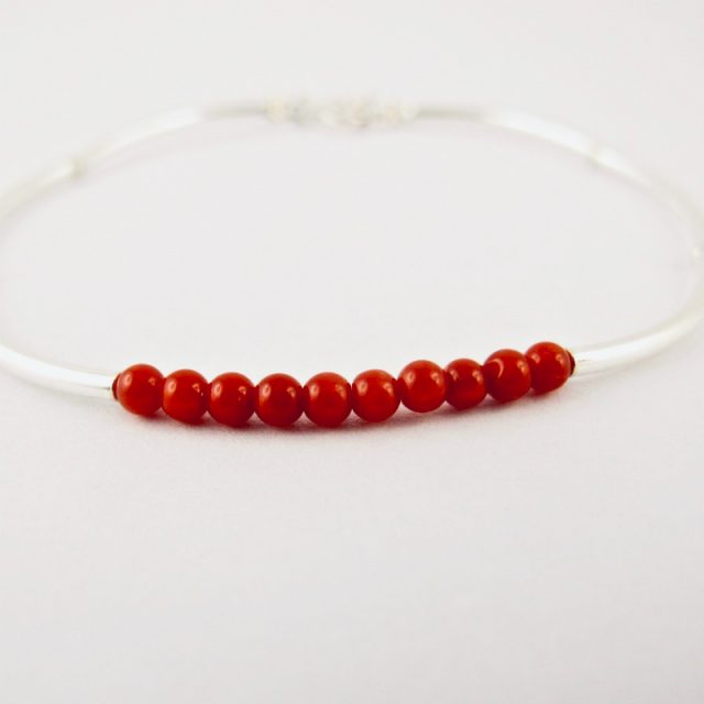 Bracelet composé d'une constellation de 10 perles de 3 mm  de véritable corail rouge de Méditerranée,et de tubes jonc de 2 cm en argent 925