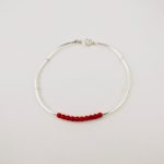 Bracelet composé d'une constellation de 10 perles de 3 mm  de véritable corail rouge de Méditerranée,et de tubes jonc de 2 cm en argent 925