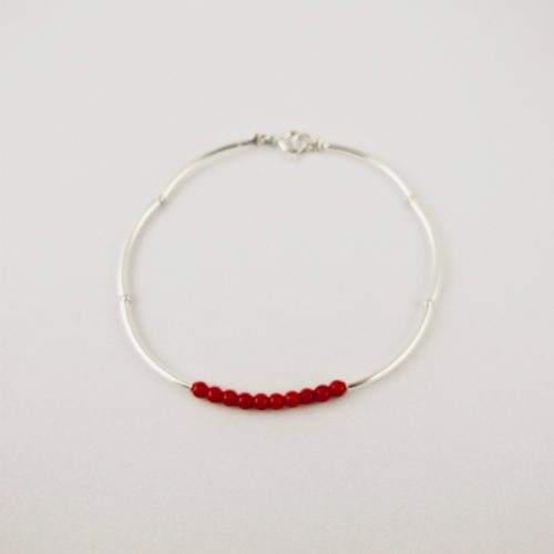 Bracelet composé d'une constellation de 10 perles de 3 mm  de véritable corail rouge de Méditerranée,et de tubes jonc de 2 cm en argent 925