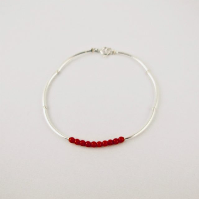 Bracelet composé d'une constellation de 10 perles de 3 mm  de véritable corail rouge de Méditerranée,et de tubes jonc de 2 cm en argent 925