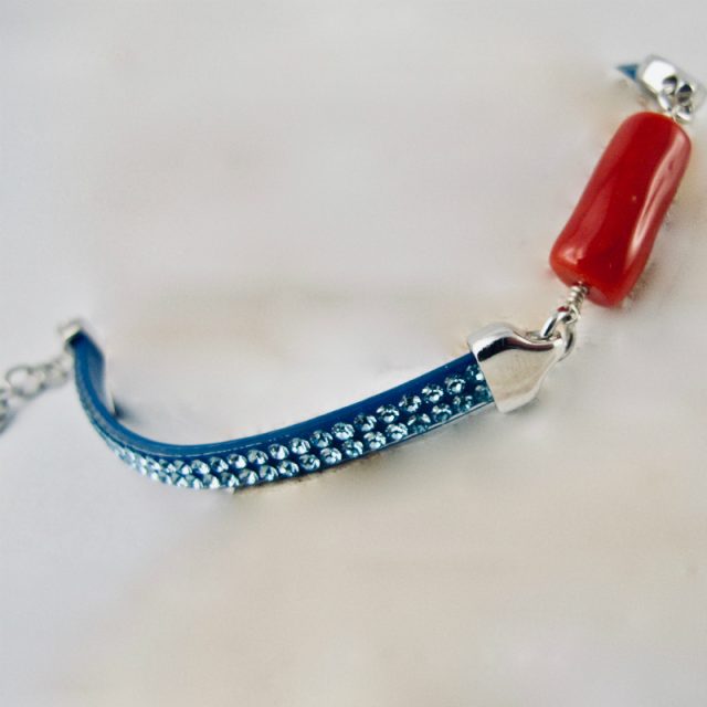 Bracelet miss Swaro, véritable corail rouge de Méditerranée et cristal de swarovski, sur argent 925/1000. Deux délicates rangées de pierres couleur caramel sont serties sur un ruban silicone au rendu velouté, ornant une barrette de corail rouge