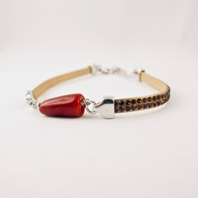 Bracelet miss Swaro, véritable corail rouge de Méditerranée et cristal de swarovski, sur argent 925/1000. Deux délicates rangées de pierres couleur caramel sont serties sur un ruban silicone au rendu velouté, ornant une barrette de corail rouge